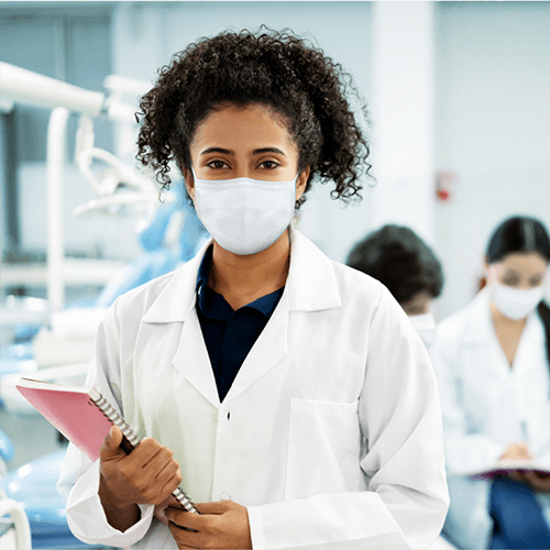 A dentist holding a folder while smiling