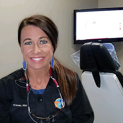 Nurse posing for picture in front of treatment chair