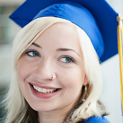 A young graduate wearing her blue cap and yellow tassel 