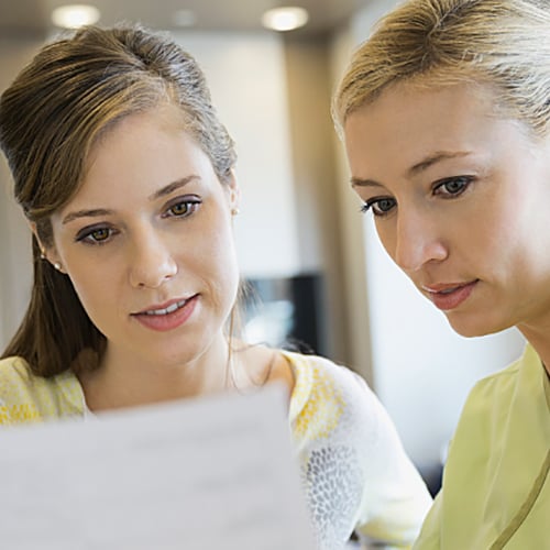 Nurse and patient standing shoulder to shoulder while looking at paperwork