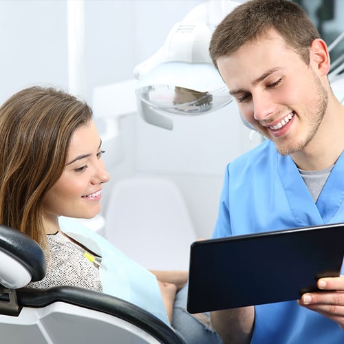 happy-dentist-patient-commenting-treatments-tablet