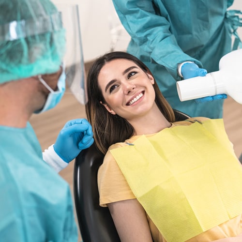 man-dentist-operating-young-smiling-woman