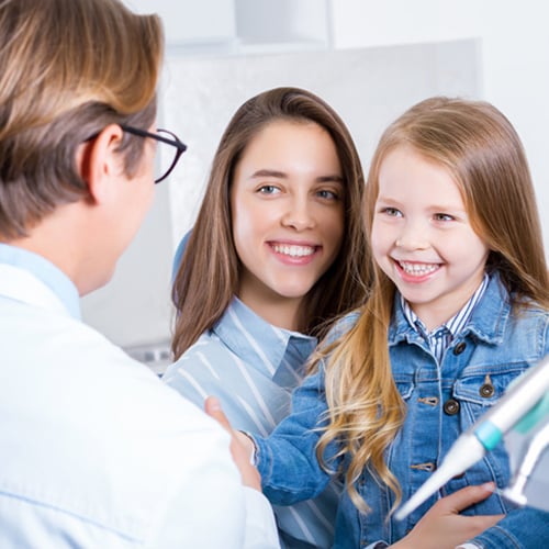 Mother and daughter talking to dental professional