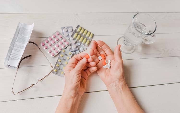 #46_senior-hands-pills-drugs-on-table