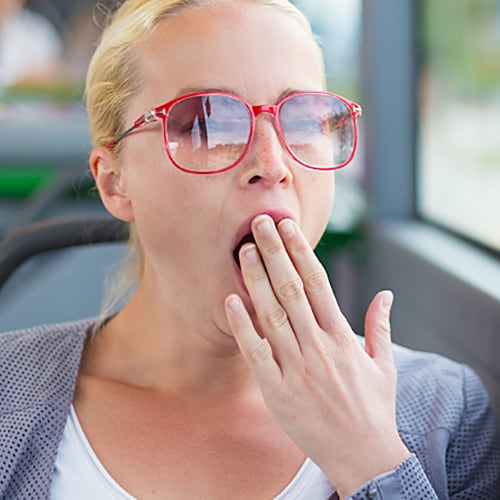 Women on the bus wearing sunglasses and yawning