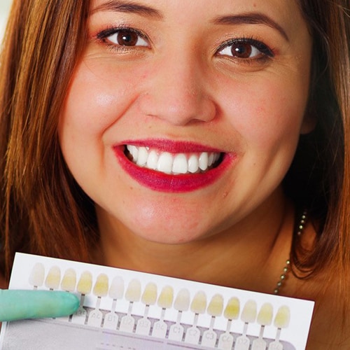 woman-smiling-behind-teeth-whitening-samples