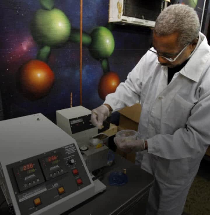 A scientist wearing a lab coat working with machines and ingredients